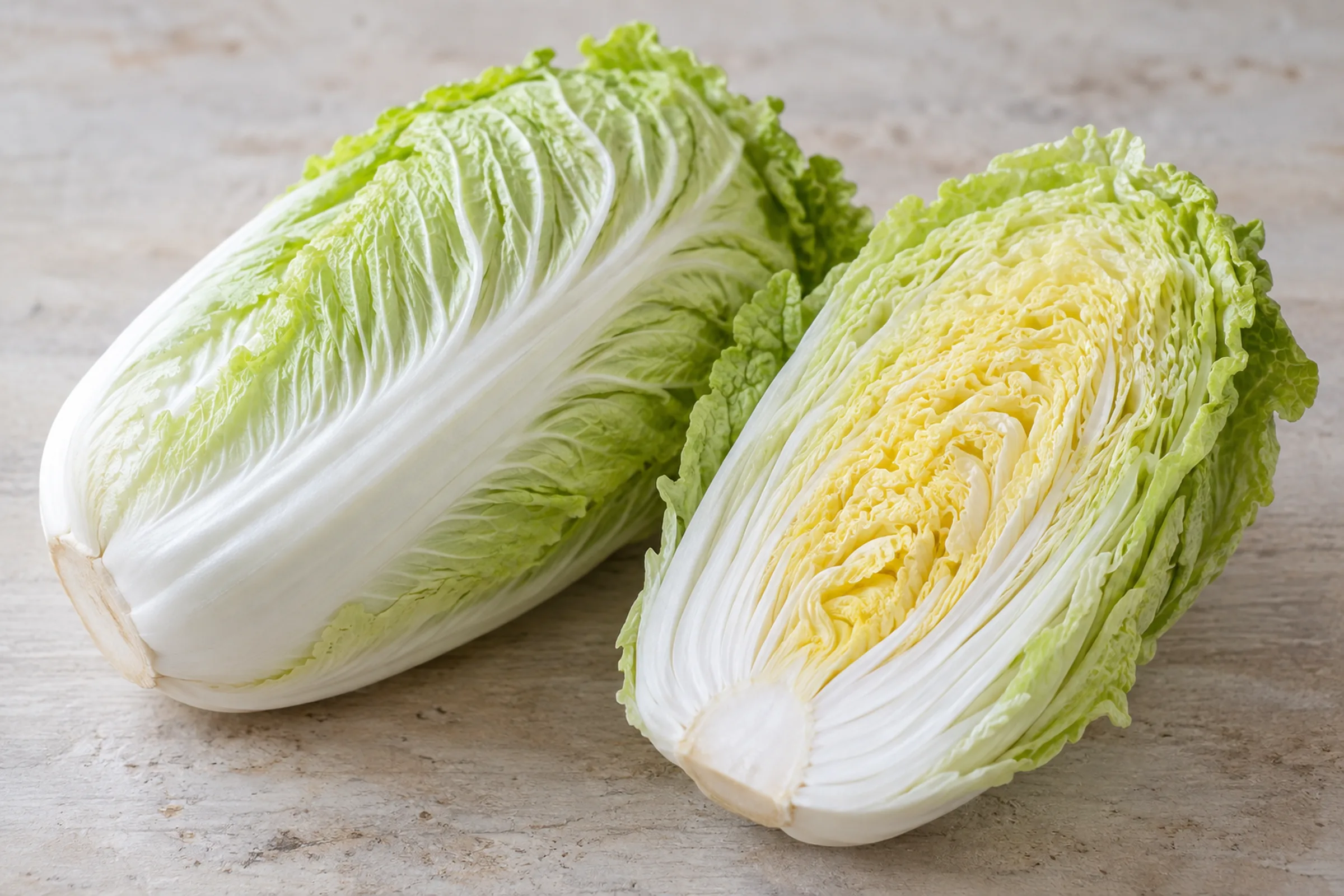 A whole napa cabbage head with pale, crinkled leaves